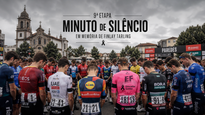 Pelotão em minuto de silêncio antes da nona etapa da Volta a Portugal 2026, em homenagem a Finlay Tarling. Imagem gerada por IA.